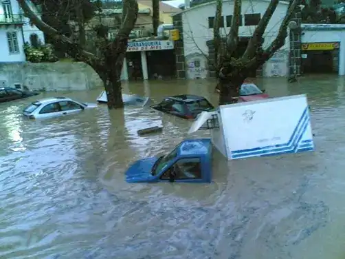 מכוניות מוצפות בעקבות שיטפונות בכביש עירוני, נציגות לנזקי מזג האוויר הקיצוניים בישראל.